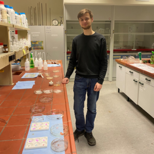 Tobias Beyhl im Chemielabor neben seinen selbstständig erzeugten Kunststoffen